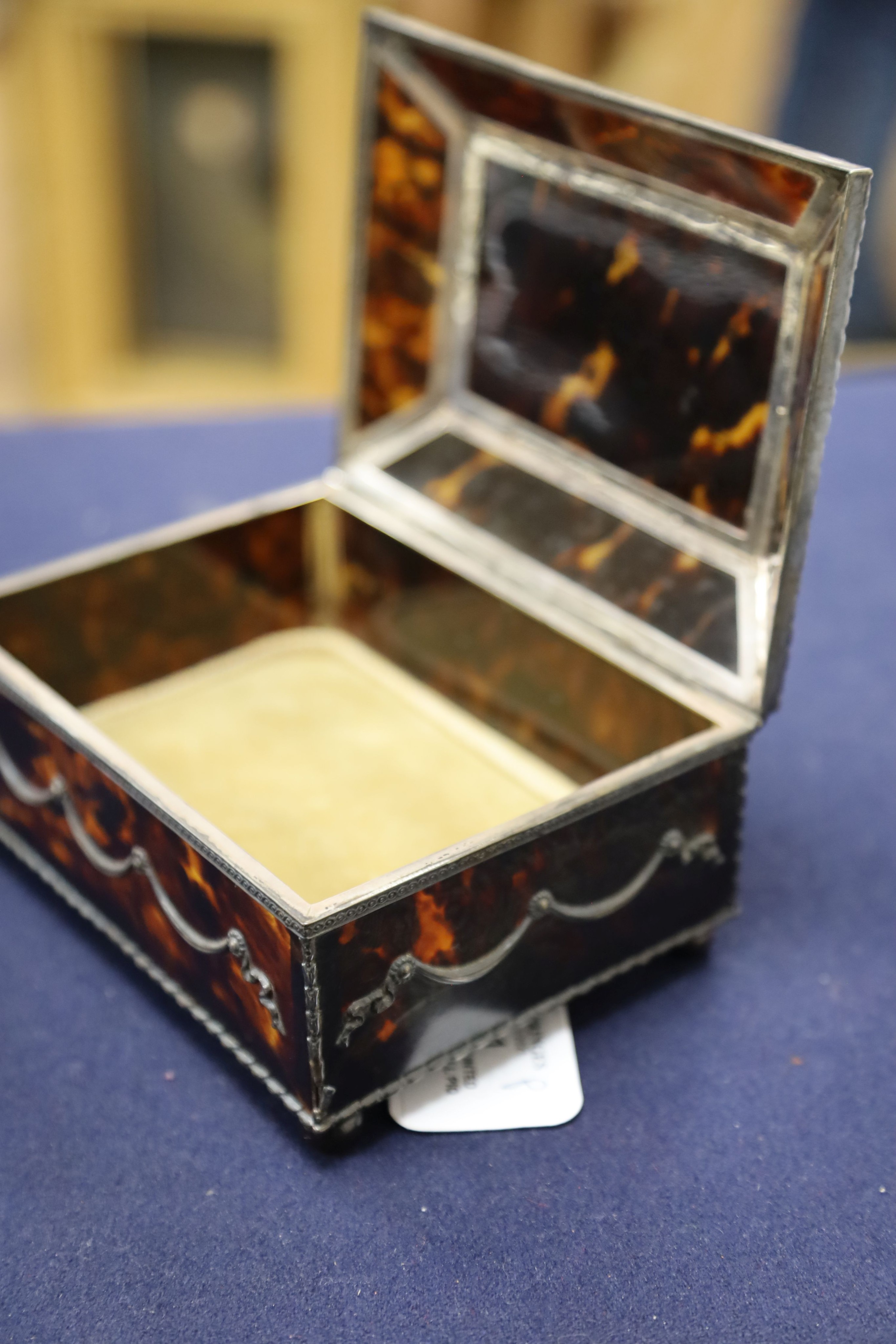 A silver-mounted tortoiseshell pique rectangular trinket box, by William Comyns, raised on four ball feet, London, 1904, width 15cm. 15cm